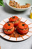 Roasted stuffed tomatoes with brown rice and nuts on ceramic plate