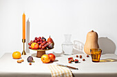 Elegant autumn fruit arrangement on a table with candle