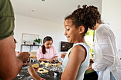 A multi-ethnic family enjoying baking biscuits together