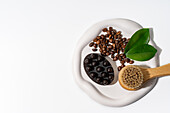 Coffee beans and scrub on a white background for skin care