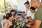 Family bonding while baking biscuits together in the kitchen