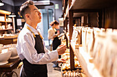 Chocolate shop employee browsing through the products