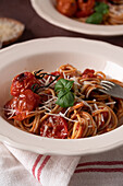 Spaghetti with tomato sauce, grilled cherry tomatoes and fresh basil