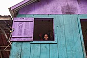 Benin, lakeside city of Ganvié, woman at the window