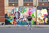 Canada, Quebec province, Montreal, the artist Ankhone, graphic designer, illustrator, painter and member of the ASHOP collective in front of one of his works, collaborative mural aimed at women and to open up mentalities as part of Under Pressure International Graffiti Convention