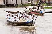 Benin, lakeside city of Ganvié, faithful going to the church by boat downtown