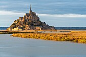 France, Manche, Mont Saint Michel Bay listed as World Heritage by UNESCO, Abbey of Mont Saint Michel and River Couesnon at sunset