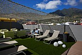 Spain, Canary Islands, Palma Island, Los Llanos de Aridane, man on a deckchair on the terrace of the Benohoare hotel open to the mountains