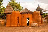 Benin, Nothern distict, Atacora mountains area, Koussoukoingou, woman in her tata made with banco (soil mixed with straw), traditional defensive two-storey habitat typical of northern Benin