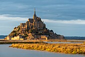 France, Manche, Mont Saint Michel Bay listed as World Heritage by UNESCO, Abbey of Mont Saint Michel and River Couesnon at sunset