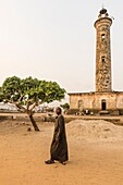 Ivory Coast, Grand Bassam,man walking in front of the lighthouse