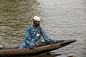 Benin, lakeside city of Ganvié, man in his dugout