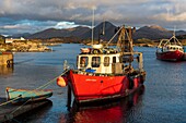 Ireland, County Galway, Connemara, Ballynakill, wooden boats and fishing boats in the harbour, Tully Mountains and Twelve Bens mountains in the background