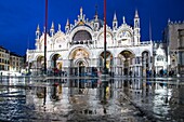 Italy, Veneto, Venice, St. Mark's Basilica and its reflection in the puddles of St. Mark's Square at dusk