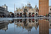 Italy, Veneto, Venice, St. Mark's Basilica and its reflection in the puddles of St. Mark's Square