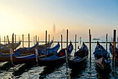 Italien, Venetien, Venedig, von der UNESCO zum Weltkulturerbe erklärt, Gondeln am Becken von San Marco (Bacino di San Marco) mit der Insel und der Kirche San Giorgio Maggiore im Hintergrund