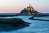 France, Manche, Mont Saint Michel Bay listed as World Heritage by UNESCO, Abbey of Mont Saint Michel and River Couesnon at dusk