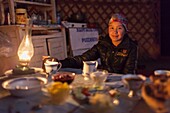 Kyrgyzstan, Naryn Province, Son-Kol Lake, altitude 3000m, portrait of a Kyrgyz girl in front of a meal in a yurt