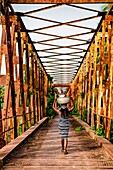 Benin, Grand Popo, woman back from the market on the old bridge