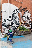 Canada, Province of Quebec, Montreal, Villeray-Saint-Michel-Parc-Extension borough, Villeray district, bike ride before mural fresco EM X VILLERAY by EN MASSE collective in an alley between avenue Henri-Julien and Drolet Street