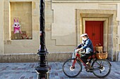 France, Paris, street art and cyclist in rue du Prevôt