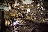 Ecuador, Galapagos-Archipel, von der UNESCO zum Weltnaturerbe erklärt, Insel Santa Cruz, Reservat El Chato, Wanderer durchqueren einen Lavatunnel