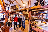 France, Rhone, Lyon, historic site listed as World Heritage by UNESCO, Mattelon workshop, on the right the hand loom which was used to make the wedding dress of Queen Elisabeth II, Georges Mattelon the owner and two other former engineers Claude Duvernay, Jean-Paul Lamarie who work in preservation and restoration