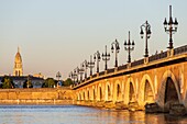 Frankreich, Gironde, Bordeaux, von der UNESCO zum Weltkulturerbe erklärtes Gebiet, die Pont de Pierre über die Garonne, eine 1822 eingeweihte Brücke aus Backstein und Stein mit Gewölbe, im Hintergrund die Kirche Sainte-Marie-de-la-Bastide