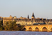 Frankreich,Gironde,Bordeaux,von der UNESCO zum Weltkulturerbe erklärtes Gebiet,Straßenbahn auf der Pont de Pierre über die Garonne,gewölbte Brücke aus Ziegeln und Stein,im Hintergrund das Tor der Bourgogne