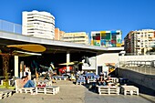 Spain, Andalusia, Costa del Sol, Malaga, the waterfront on the port, El Artsenal, bar, art gallery and The Pompidou Art Centre the Cube by Daniel Buren in the background