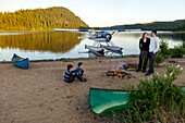 Canada, Province of Quebec, Mauricie Region, Hydravion Aventure, Saint-Maurice Wildlife Sanctuary north of Mauricie National Park, overnight camping on a sandy beach by Lake Soucis, campfire at sunset MODEL RELEASE OK