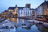 Belgium, East Flanders, Ghent, Night navigation on the Lys river along the Graslei (Herbs Quay) and the Saint Michel church in the background