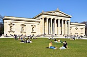 Germany, Bavaria, Munich, Königsplatz, Glyptothek, museum founded in 1830 by the King Louis 1st of Bavaria to welcome its collections of Greek and Roman sculptures, student working leaning against the neoclassical facade