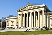 Germany, Bavaria, Munich, Königsplatz, Glyptothek, museum founded in 1830 by the King Louis 1st of Bavaria to welcome its collections of Greek and Roman sculptures, student working leaning against the neoclassical facade