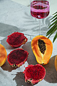 Glass with cocktail,dragon fruit,also known as pitaya,sliced pink magenta flesh with tiny black seeds,tropical fruit