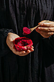 Dragon fruit,also known as pitaya,sliced pink-magenta coloured flesh with tiny black seeds,in the hands of a woman,tropical fruit