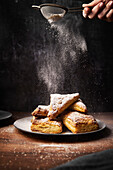 Apple turnover with icing sugar on a wooden base