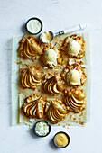 Freshly baked pear and almond tartlets on brown baking paper, finished with vanilla ice cream on a white marble base