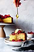Olive oil cake with berries,one hand drizzles honey
