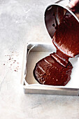 Pouring brownie batter into a pan