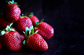 Frische rote Erdbeeren Closeup auf dunklem Hintergrund mit negativem Raum.