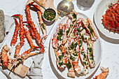 Delicious crab legs garnished with fresh herbs and garlic serve as the focal point of this mouth-watering dish. Paired with white wine, this gourmet meal is both visually appealing and full of flavors