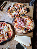 Frisch aus dem Ofen kommende Sauerteigpizza,auf einer Seite leicht angebrannt und mit Parmesan serviert
