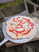 Sauerteigpizza frisch aus dem Ofen,auf einer Seite leicht angebrannt und mit Parmesan belegt