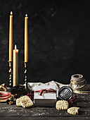 Table with stamped biscuits and matching gift box. Blown-out candles, biscuit stamps and Christmas decorations. Rustic atmosphere; atmospheric background