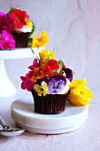 Japanisch inspirierter Karotten-Cupcake mit Apfelminze und essbaren Blüten,Nahaufnahme.