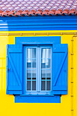 Portugal, Aveiro. Brightly colored blue window on a yellow building.