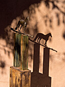 USA, New Mexico, Sante Fe. Bronze statue of a horse on a metal stand and a shadow on the wall. (Editorial Use Only)