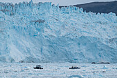 Kleines Schiff schwimmt zwischen dem Eis unterhalb des Eqi-Gletschers,Westgrönland,Dänemark,Polargebiete