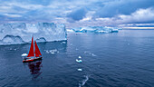 Aerial of a red sailing boat in the Ilulissat Icefjord, UNESCO World Heritage Site, Western Greenland, Denmark, Polar Regions